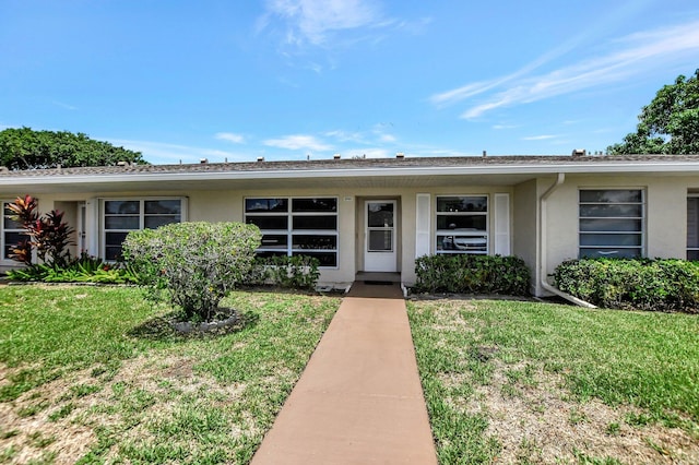 single story home featuring a front lawn