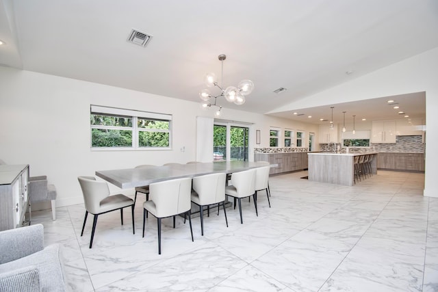 dining space with vaulted ceiling, light tile patterned floors, and an inviting chandelier