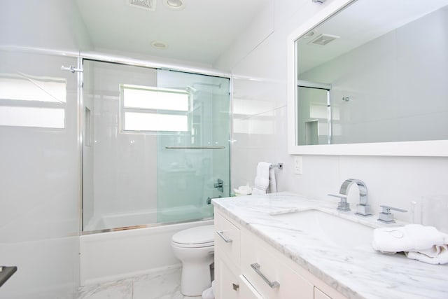 full bathroom with tile patterned flooring, vanity, bath / shower combo with glass door, and toilet