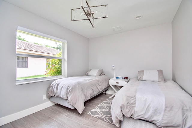 bedroom featuring hardwood / wood-style flooring and a notable chandelier