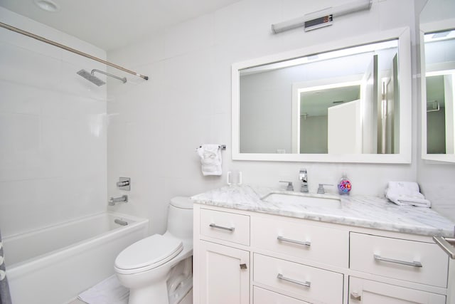 full bathroom featuring vanity, tiled shower / bath combo, and toilet