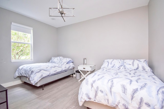 bedroom with hardwood / wood-style flooring and a chandelier