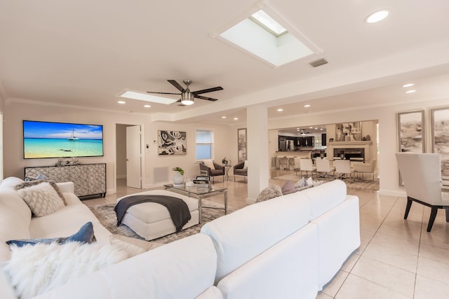 tiled living room with ceiling fan and crown molding