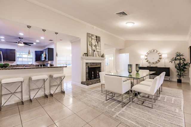 tiled dining space featuring ceiling fan and crown molding