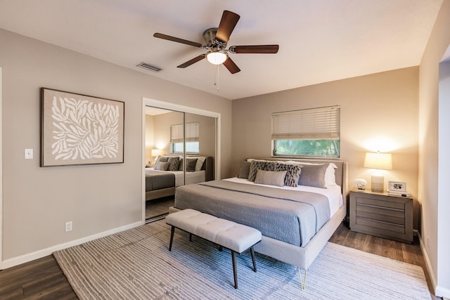 bedroom with hardwood / wood-style floors, ceiling fan, multiple windows, and a closet