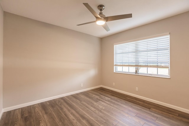 spare room with ceiling fan, dark wood-type flooring, and a wealth of natural light