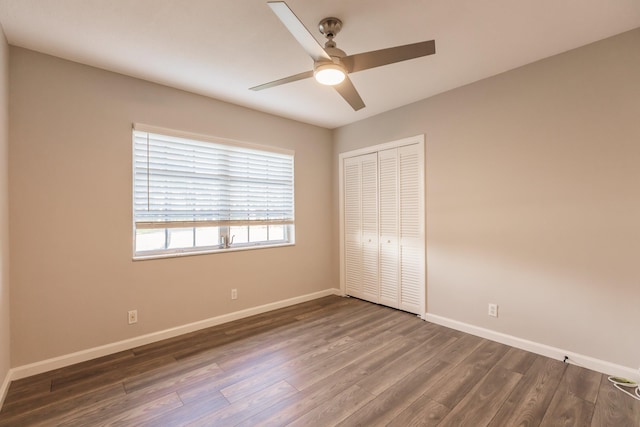 unfurnished bedroom featuring ceiling fan, dark hardwood / wood-style floors, and a closet