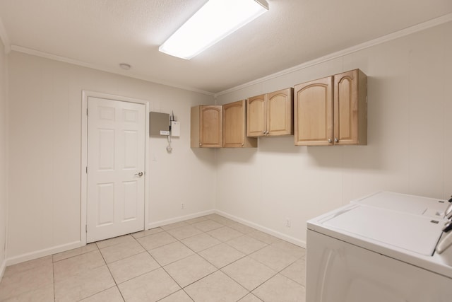 clothes washing area featuring cabinets, a textured ceiling, crown molding, light tile patterned floors, and washing machine and clothes dryer