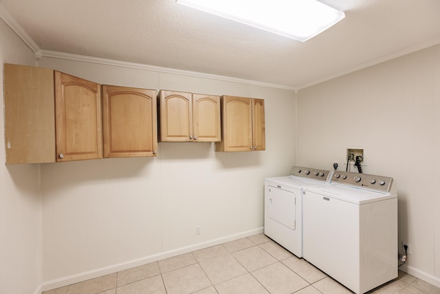 laundry area with cabinets, crown molding, washer and dryer, light tile patterned floors, and a textured ceiling