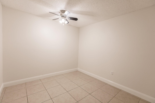 spare room with ceiling fan, light tile patterned flooring, and a textured ceiling