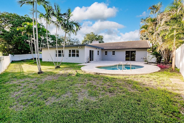 back of property featuring a fenced in pool and a yard