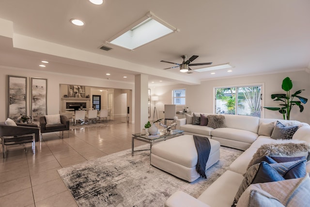 living room with ceiling fan, light tile patterned floors, and ornamental molding