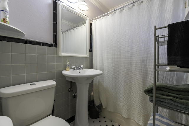 bathroom featuring tile walls, toilet, and crown molding