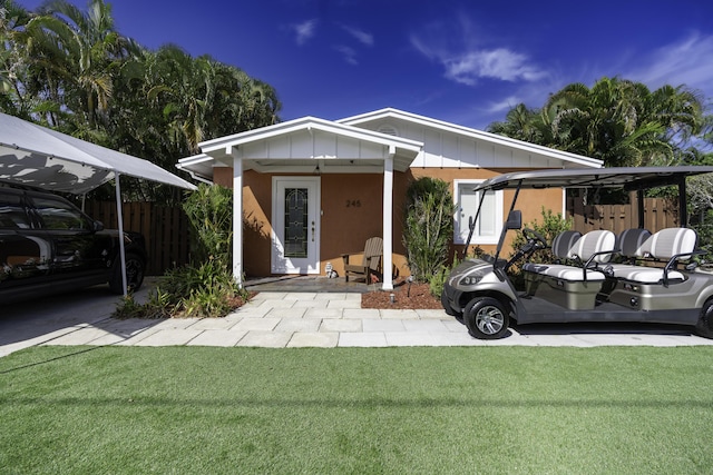 view of front of home with a front yard and a carport