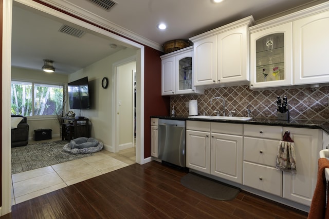 kitchen featuring dishwasher, sink, backsplash, white cabinetry, and dark stone countertops