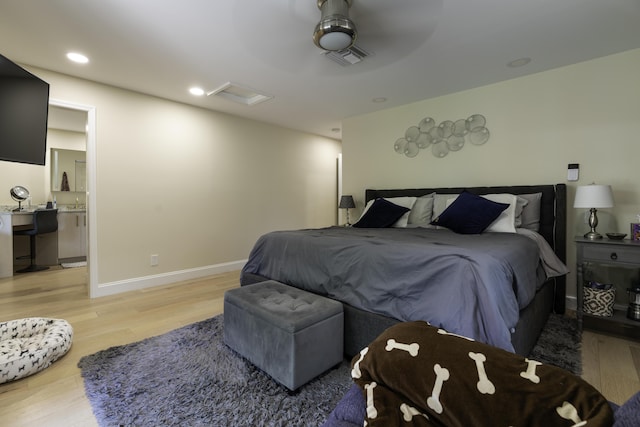 bedroom with ceiling fan, light hardwood / wood-style floors, and connected bathroom