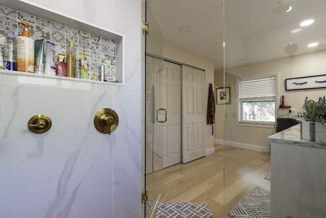 bathroom featuring walk in shower and wood-type flooring