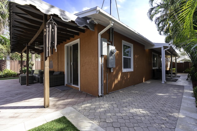 view of side of property featuring a patio area, ceiling fan, and an outdoor hangout area