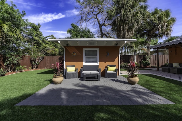 rear view of house featuring a lawn, an outbuilding, a patio, and an outdoor living space