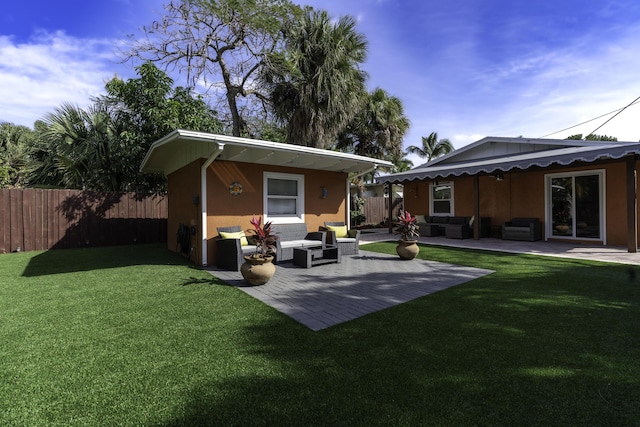 back of property featuring outdoor lounge area, a yard, and a patio