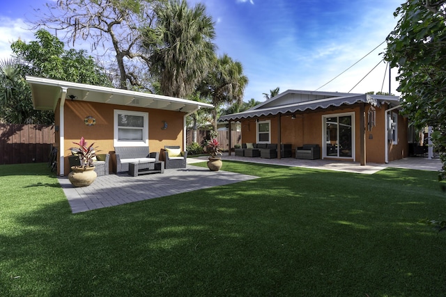 back of property with a patio area, outdoor lounge area, and a lawn