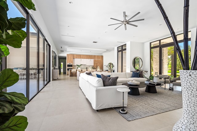 living room with ceiling fan, expansive windows, and light tile patterned floors