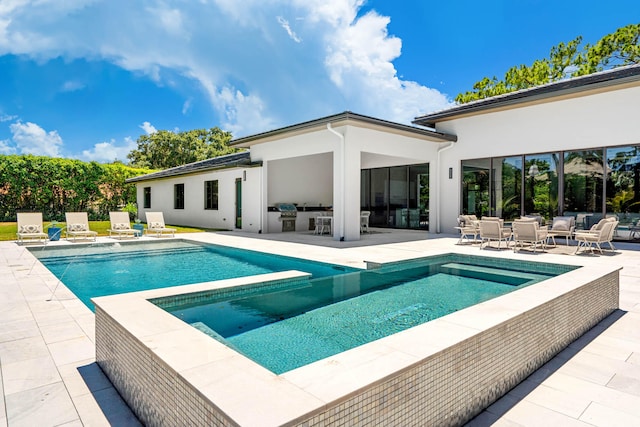 view of pool with a patio area and an in ground hot tub