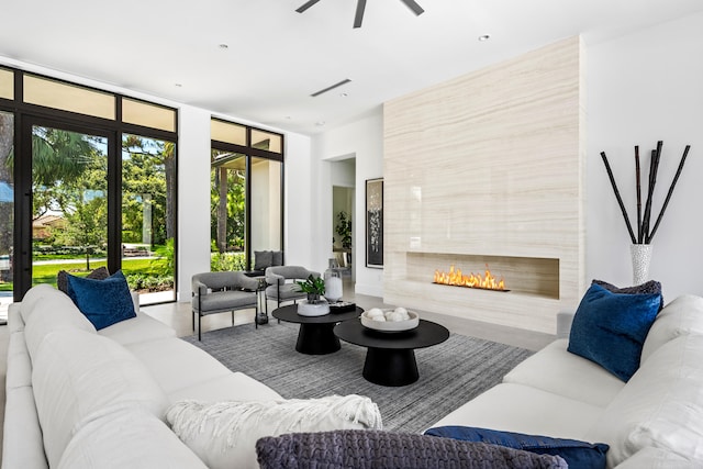 living room with ceiling fan and a fireplace