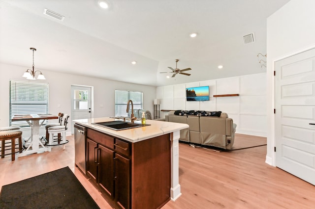 kitchen featuring sink, hanging light fixtures, stainless steel dishwasher, a kitchen island with sink, and light wood-type flooring