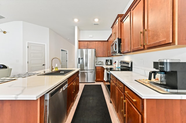 kitchen with light stone counters, sink, an island with sink, and stainless steel appliances