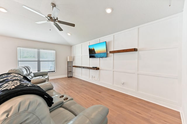 living room featuring ceiling fan, lofted ceiling, and light hardwood / wood-style flooring