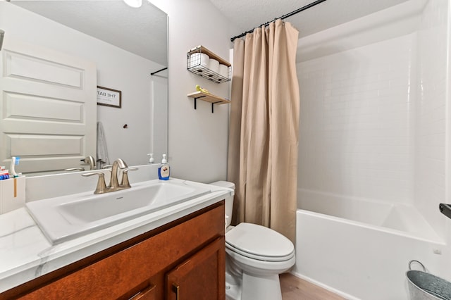 full bathroom with a textured ceiling, vanity, shower / tub combo with curtain, hardwood / wood-style flooring, and toilet