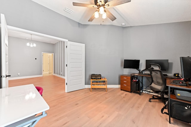 home office with lofted ceiling, light hardwood / wood-style flooring, and ceiling fan with notable chandelier