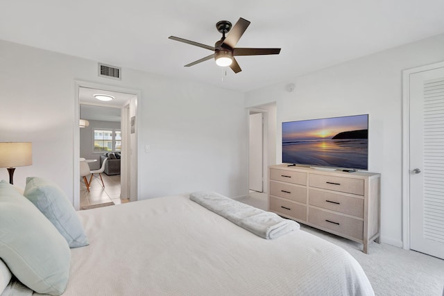 bedroom featuring light carpet and ceiling fan