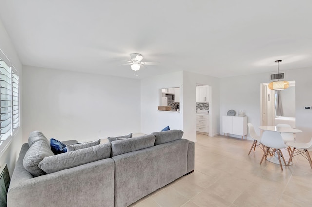 living room featuring light tile patterned flooring, ceiling fan, and plenty of natural light