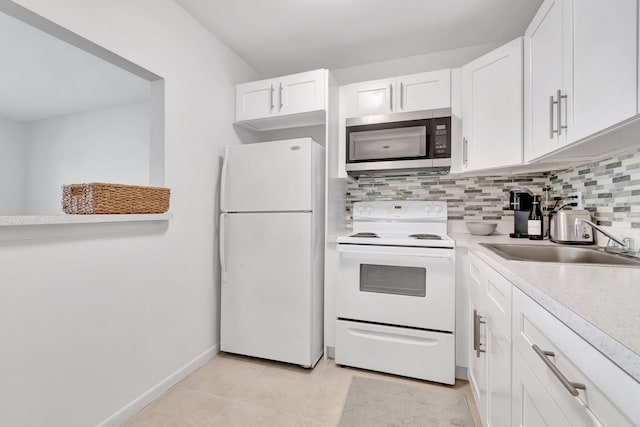 kitchen with light tile patterned flooring, decorative backsplash, white cabinets, white appliances, and sink