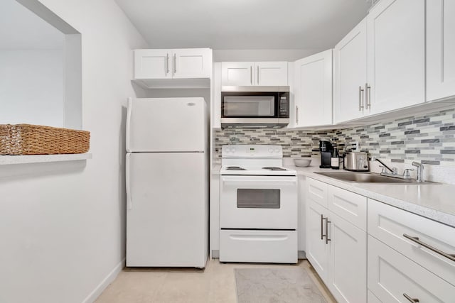 kitchen with white appliances, sink, light tile patterned floors, decorative backsplash, and white cabinetry