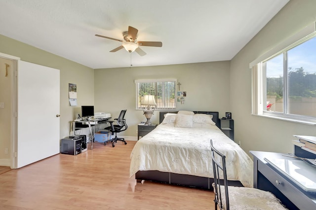 bedroom featuring multiple windows, ceiling fan, and light wood-type flooring