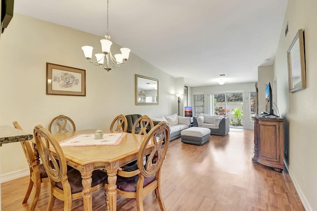 dining room with a notable chandelier and light hardwood / wood-style flooring