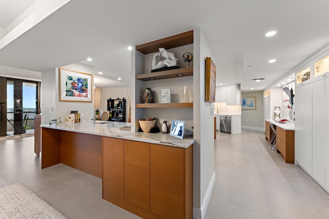 kitchen with sink, light stone counters, kitchen peninsula, light tile patterned floors, and dishwasher