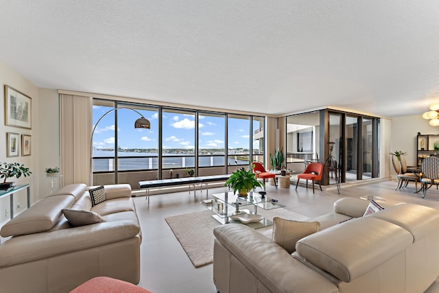 tiled living room with a water view, a textured ceiling, and a healthy amount of sunlight