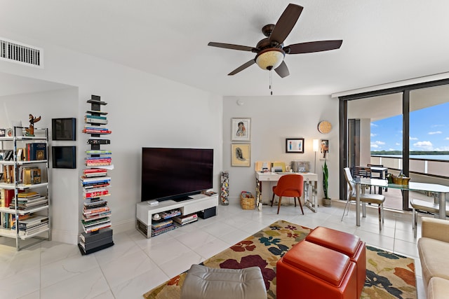 living room with a wall of windows, ceiling fan, and light tile patterned floors