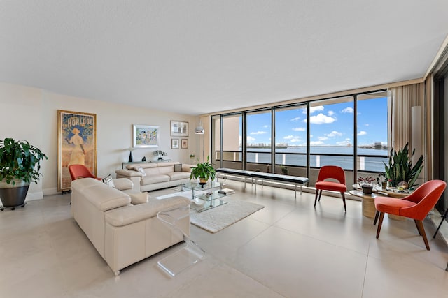 tiled living room featuring floor to ceiling windows and a water view