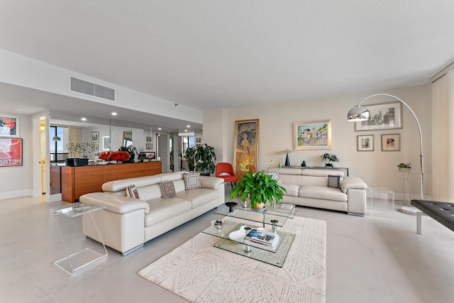 tiled living room featuring a textured ceiling