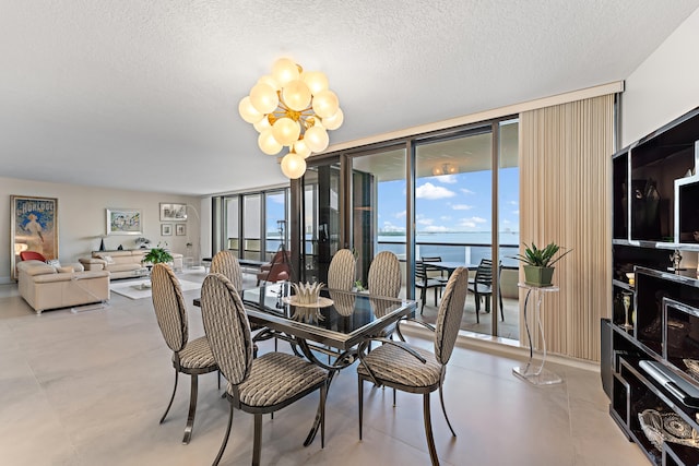 dining area with a notable chandelier, expansive windows, a textured ceiling, and light tile patterned floors