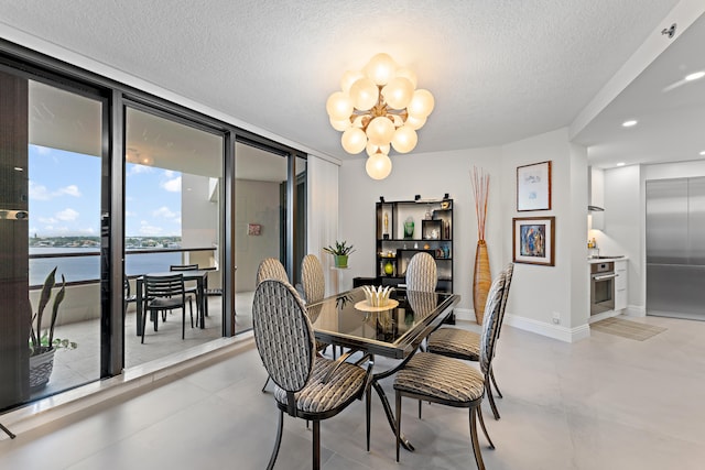 tiled dining area with floor to ceiling windows, a water view, a notable chandelier, and a textured ceiling