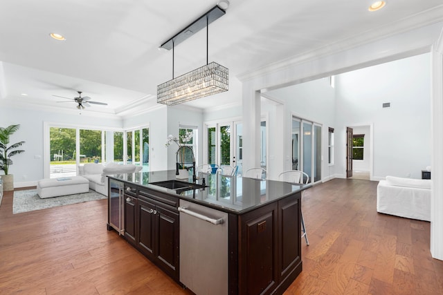 kitchen with dark brown cabinetry, sink, pendant lighting, a center island with sink, and dishwasher