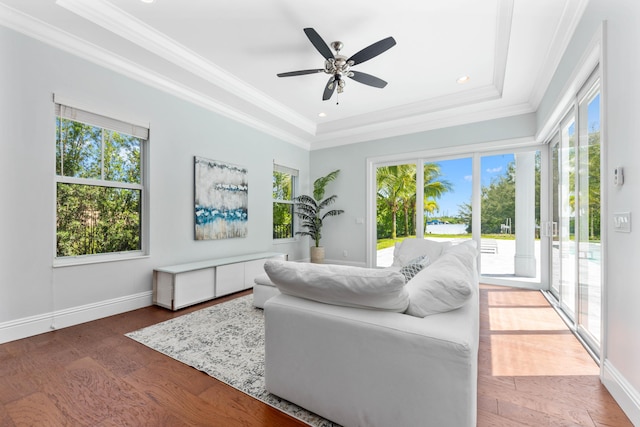 living room with ceiling fan, wood-type flooring, crown molding, and a tray ceiling