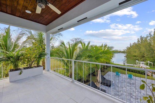 balcony featuring a water view and ceiling fan