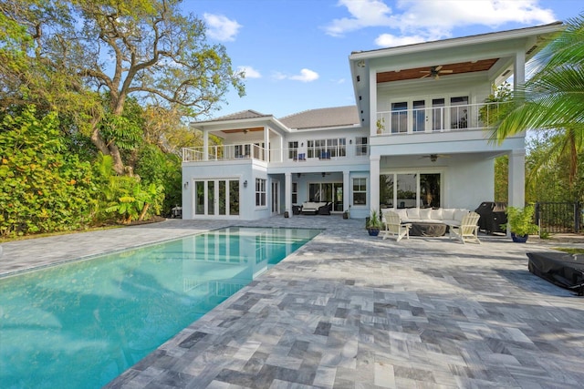 back of property with an outdoor living space, a balcony, a patio, and ceiling fan